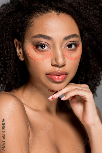 nude african american girl with hydrogel eye patches, isolated on grey