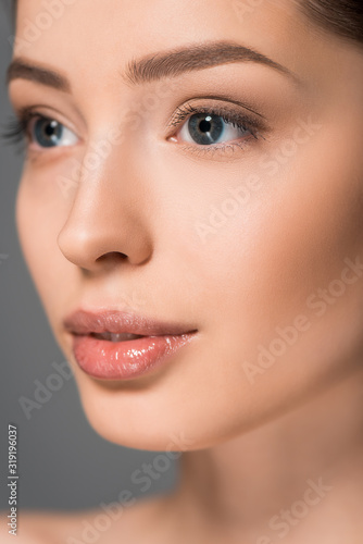 portrait of beautiful young woman with clean face, isolated on grey