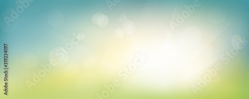 A fresh spring blue sunny sky background with blurred warm sunny glow.