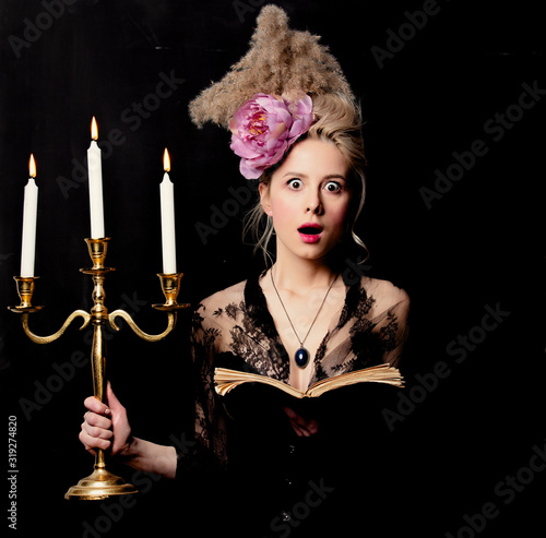 Beautiful blonde countess with a book and candlestick