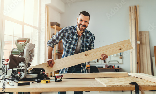 young male carpenter working in workshop