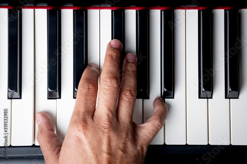 right hand playing a A Minor inversion chord on the piano