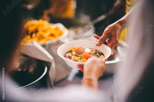 Food donation to hungry people, poor hands waiting to receive free food from volunteers