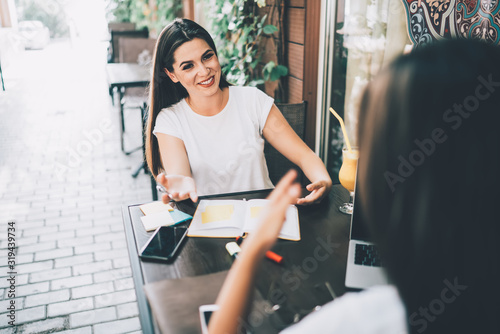 Positive ladies discussing work at pavement cafe