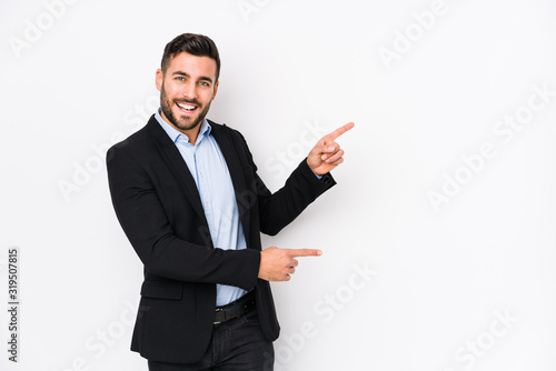 Young caucasian business man against a white background isolated excited pointing with forefingers away.