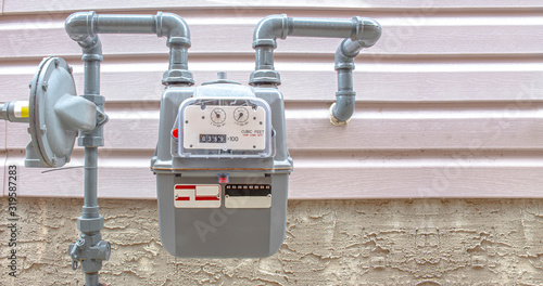 Residential urban natural gas meter measuring gas consumption, outside house gas meter