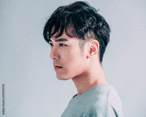 side view of young smiling handsome man isolated on gray background