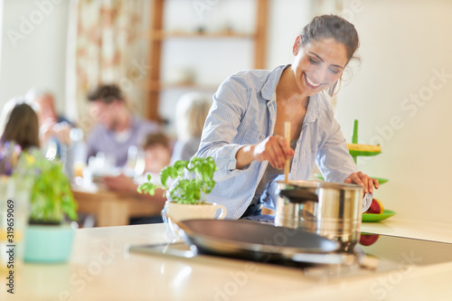 Frau beim kochen am Herd rührt im Kochtopf