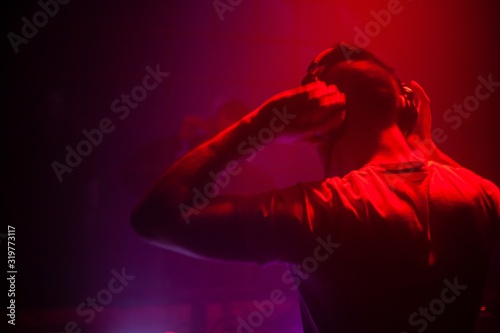 DJ performing electronic music for a live audience in a dark club