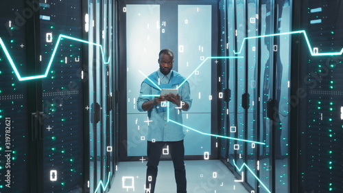 Data Center. Digitalization of Information. African Server Specialist with Digital Tablet Working in High Tech Data Center Server Room. 3D Looped Animation of Data Flow with Graphic Elements, Glowing