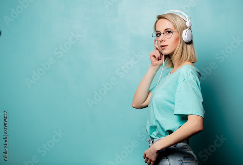 Style blonde woman in glasses with headphones