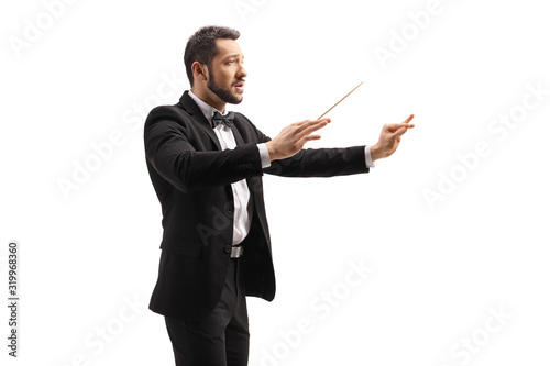 Male conductor in a suit conducting with a baton and gesturing with hand