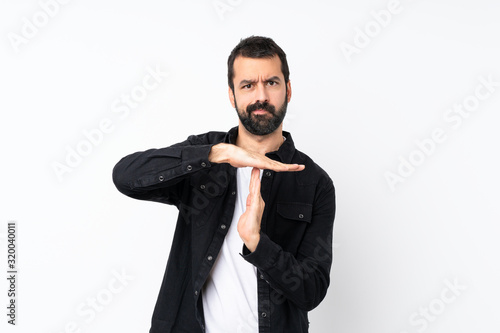 Young man with beard over isolated white background making time out gesture
