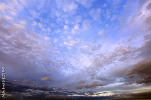 Burzowe chmury na błękitnym niebie w czasie zachodu słońca. 
