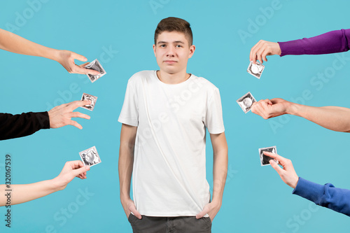 A teenager in a white T-shirt looks uncertainly forward