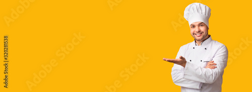 Cook Man Gesturing Showing Something Standing Over Yellow Background, Panorama