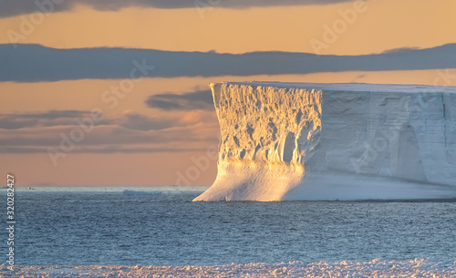 Goergeous sunset over giant icebergs and stunning polar landscapes along the coast of the Antarctic Peninsula