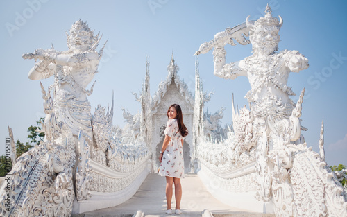 An asian woman standing in front of Wat Rong Khun, The white temple in Chiang Rai, Thailand