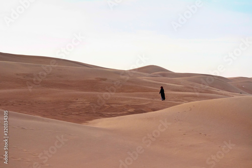 Verschleierte Frau alleine in der Wüste