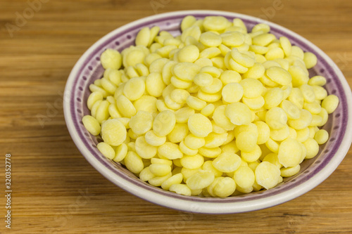 heap of yellow cocoa butter pieces in a bowl - theobroma oil