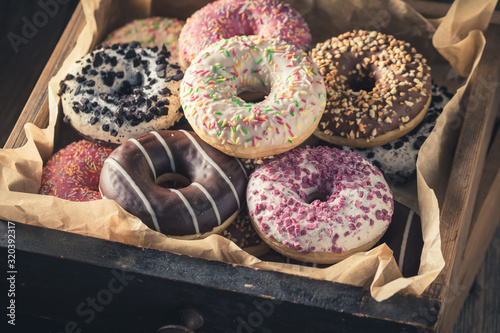 Closeup of tasty donuts in old wooden boxes
