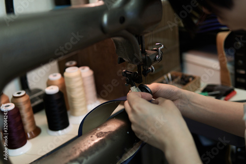 ミシンで革を縫う女性の手元