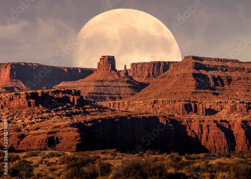 Sunset on Canyonlands National Park and Full Moon rising behind mountains