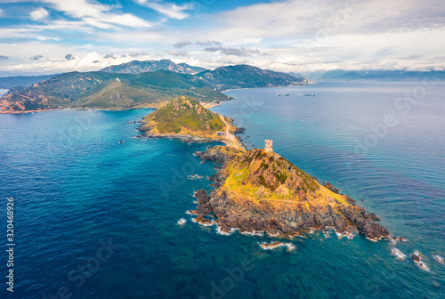 View from flying drone. Amazing spring scene of popular tourist destination Torra di a Parata - 16th-century Genoese tower reached by a rocky nature trail, Corsica island, France, Europe.