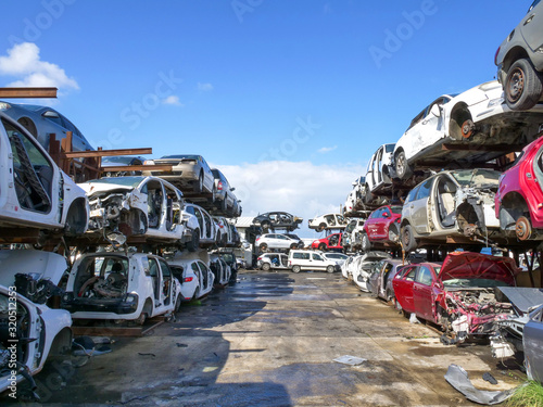 Large Salvage Car parts and Vehicles lot, with rows of stacked totalled Cars