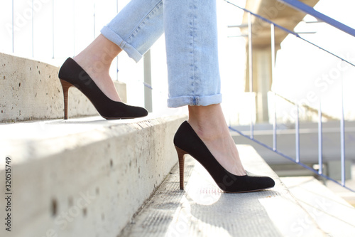 Profile of woman legs wearing high heels walking down stairs