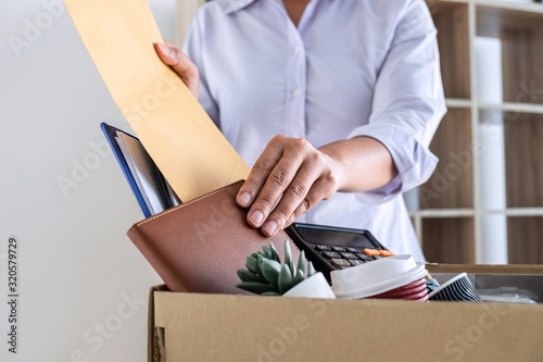 Images of stress of woman employee has a brown cardboard box and intend sending resignation letter to boss employer consider in order to contract for quit or layoff of job leaving from work