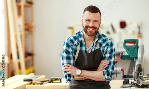 young male carpenter working in workshop.