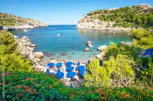 Small beach with tourists, umbrellas and sun chairs in Anthony Quinn bay (Rhodes, Greece)