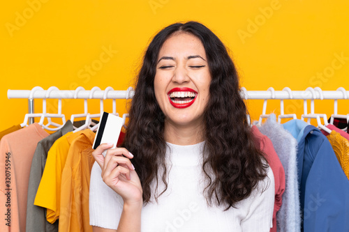Mixed race woman in a clothing store and holding a credit card