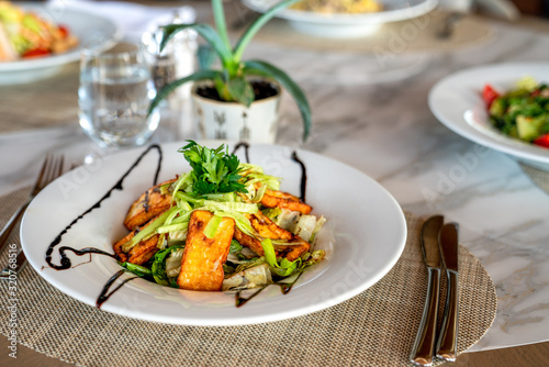A delicious grilled or roasted hellumi cheese salad is served in a elegance restaurant or hotel.