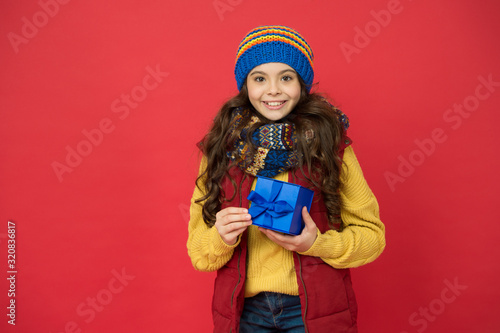 Pick some winter gifts for yourself. Wish list. Feeling grateful. Holidays season. Happy childhood. Christmas gifts and souvenirs. Winter holidays. Happy kid in winter outfit red background