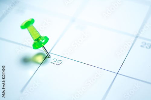 Green push pin on calendar 29th leap year day of the month