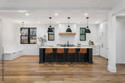 Beautiful white kitchen with dark accents in new modern farmhouse style luxury home