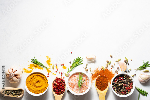 Bright aromatic set of spices on white marble table top view with copy space for your text.