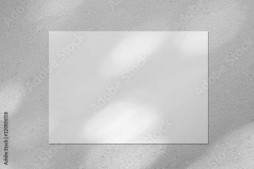 Empty white horizontal rectangle poster or business card mockup with diagonal dappled light spots on gray concrete wall. Flat lay, top view. For advertising, brand design, stationery presentation.