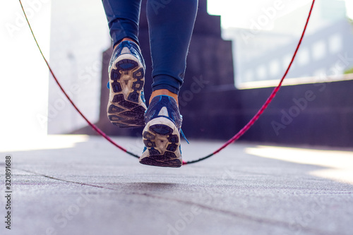 Close up of an athletic person's feet jumping rope outdoor