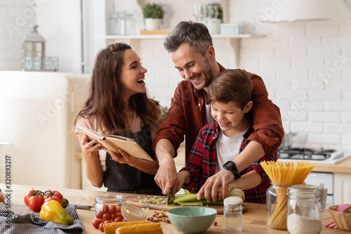 Happy family laughing loud and cooking on kitchen