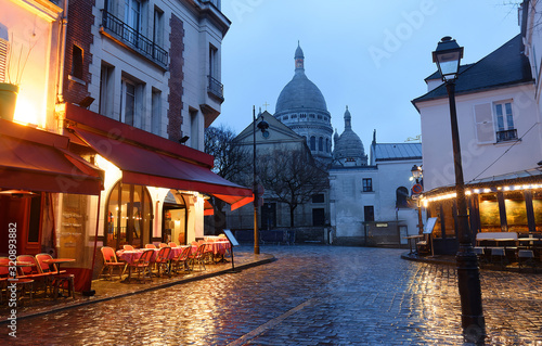 The Place du Tertre with tables of cafe and the Sacre-Coeur in the rainy morning, quarter Montmartre in Paris.