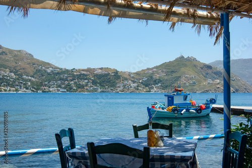 A greek taverna by the seaside on the quiet, traffic free island of Telendos. On the horizon is the neighbousing, larger, island of Kalymnos.