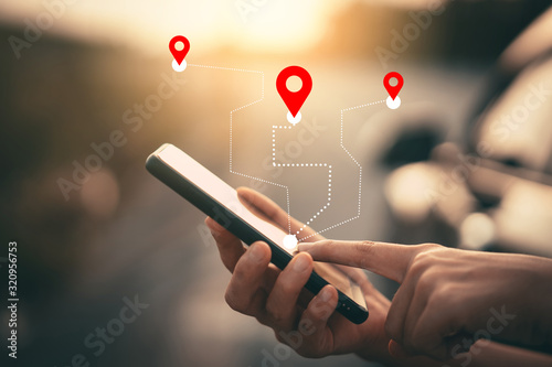 Man hand using smartphone with gps navigator map icon on blur street background.