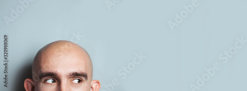 Emotional portrait of surprised bald man. half-face. Copyspace for text. Vertical.