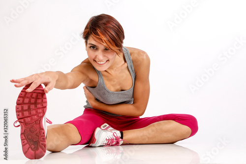 ragazza sportiva con i capelli a caschetto fa stretching dopo aver fatto attvità fisica - isolata su sfondo bianco