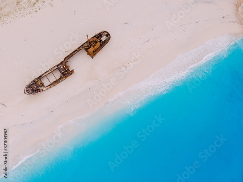 Top-down view of the old rusty ship lying on the beach.