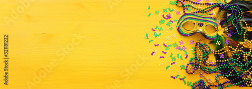 Holidays image of mardi gras masquarade venetian mask over yellow background. view from above