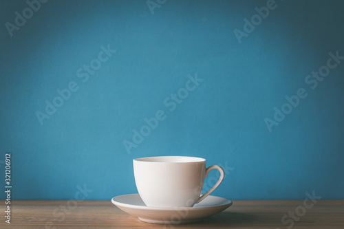 cup of coffee on wooden table with blue background